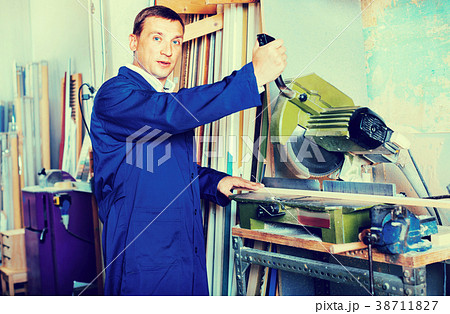Man operating circular saw in wood workshop Man operating circular saw in wood workshop 38711827