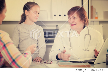 Little girl and mother with mature medical worker 38712442