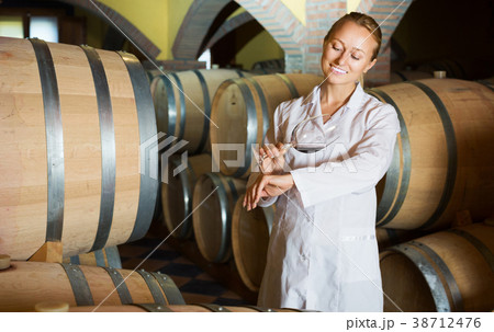 Woman checking ageing process of wine Woman checking ageing process of wine 38712476