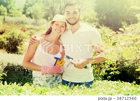 Young couple gardening together . Young couple gardening together . 38712560