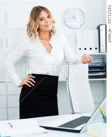 Young girl in business clothes is standing near table in office 38712562
