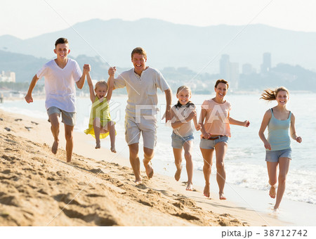 Laughing family of six people happily running together Laughing family of six people happily running together 38712742