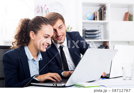 Two office workers work using laptops 38712767