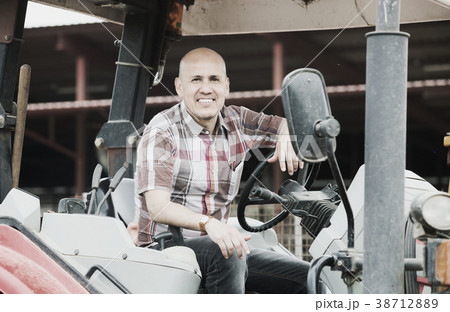 Farmer working at agricultural machinery Farmer working at agricultural machinery 38712889