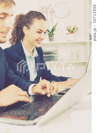Glad business female assistant wearing formalwear using laptop Glad business female assistant wearing formalwear using laptop 38712898
