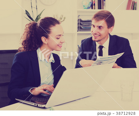 Two office workers work using laptops Two office workers work using laptops 38712928