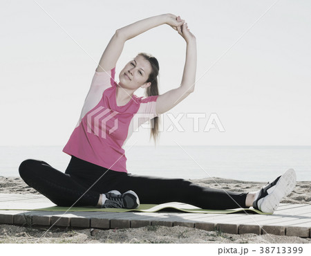 Woman training yoga poses on beach Woman training yoga poses on beach 38713399