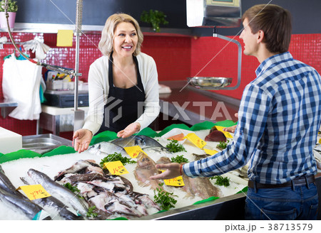 Customer buying fish in shop. 38713579
