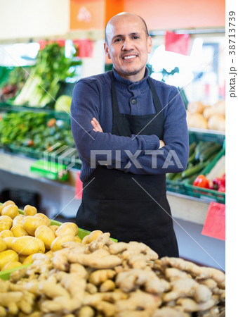 Mature positive seller standing near display with ginger Mature positive seller standing near display with ginger 38713739