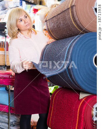 Smiling woman customer buying colorful carpeting 38713938