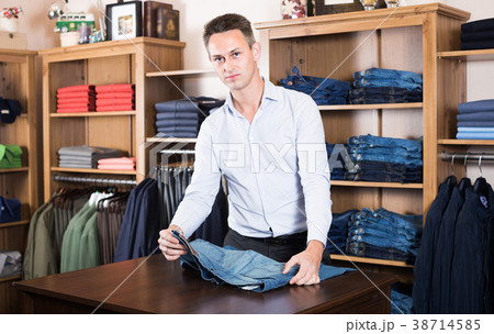 Man is deciding on for new jeans Man is deciding on for new jeans 38714585