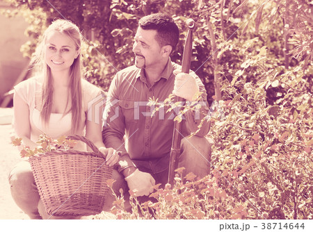 Woman and man holding basket with flowers. 38714644