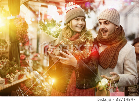 Woman and man choosing decorations and Christmas tree Woman and man choosing decorations and Christmas tree 38714847
