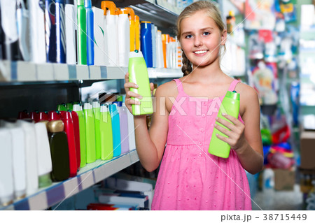 Young customer girl is choosing shampoo Young customer girl is choosing shampoo 38715449