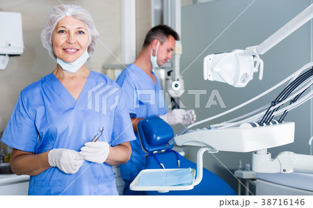 Portrait of woman dentist with dental assistant behind Portrait of woman dentist with dental assistant behind 38716146
