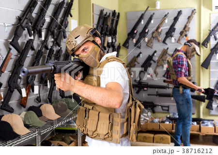 Male customers try on ammunition with weapon Male customers try on ammunition with weapon 38716212