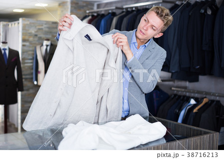 Man buyer in jacket choosing shirt 38716213