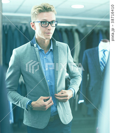 costumer in the glasses trying jacket in the shop costumer in the glasses trying jacket in the shop 38716410