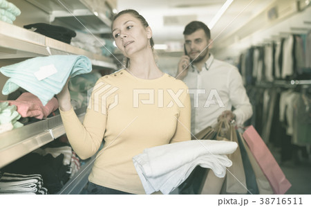 Positive woman choosing terry towels in store Positive woman choosing terry towels in store 38716511