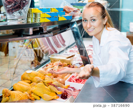 Female seller wearing uniform working with fresh meat Female seller wearing uniform working with fresh meat 38716690