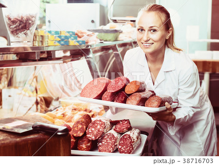 Portrait of young woman having tray with salami 38716703