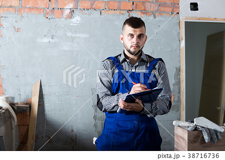 Engineer is signing documents about the report 38716736