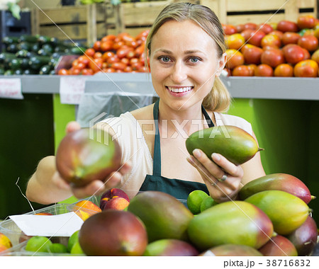 young woman selling mango at market . young woman selling mango at market . 38716832