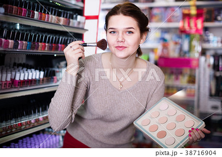 attractive woman customer deciding on compact powder in shop attractive woman customer deciding on compact powder in shop 38716904