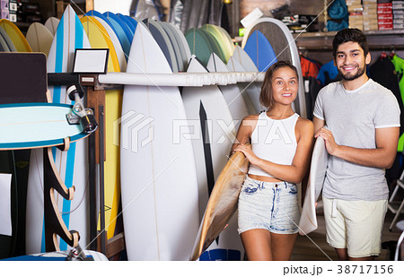 man and woman choosing surfboards 38717156
