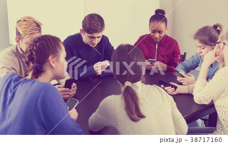 Classmates using their smartphones heavily during classes 38717160