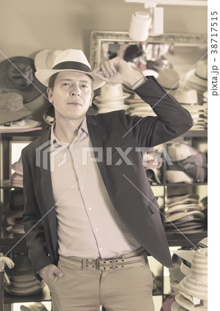 Portrait of guy try on sun hat at headwear store 38717515