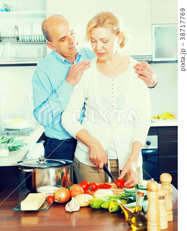 mature couple cooking together in kitchen 38717769