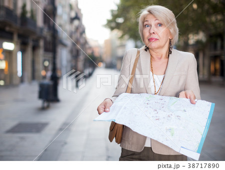 Elegant adult woman is posing with map in time walking 38717890