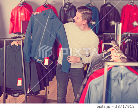 Glad man chooses clothes in shop Glad man chooses clothes in shop 38717915
