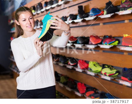 Woman choosing sport sneakers in sports store 38717917