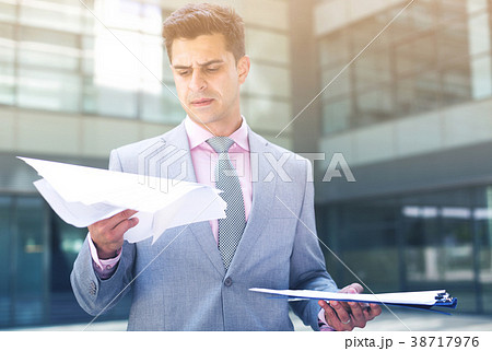 Businessman attentively reading documents 38717976