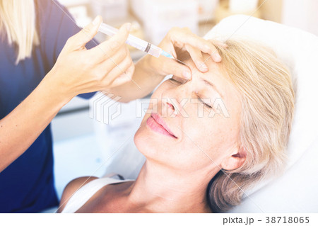 Senior woman getting facial injection 38718065