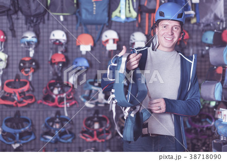 Man buying climbing equipment in sporting store 38718090