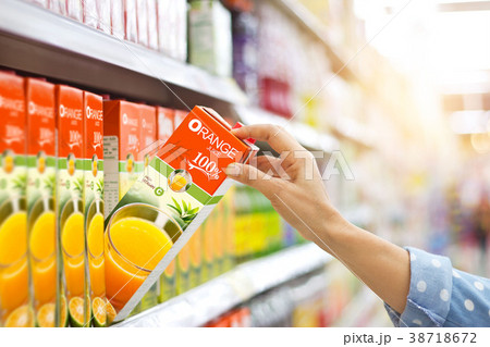 Woman hand buy orange juice on shelves supermarket 38718672