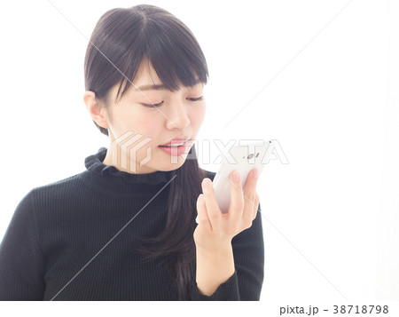 スマホに話しかける女性の写真素材