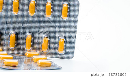 Orange capsule pills in blister pack isolated  38721803