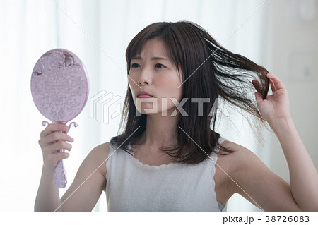 ダメージヘアを気にする若い日本人女性 38726083