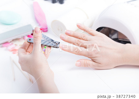 Woman doing manicure with tweezers Woman doing manicure with tweezers 38727340