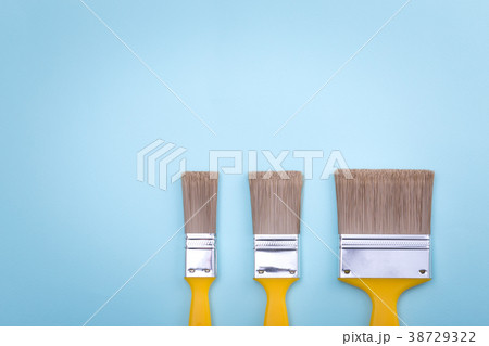Two brushes for painting on blue paper texture Two brushes for painting on blue paper texture 38729322