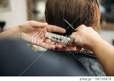 The hands of young barber making haircut to 38730878