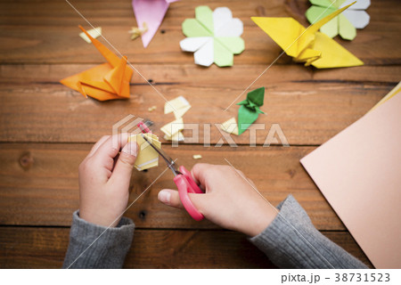 折り紙で遊ぶ子供の手の写真素材