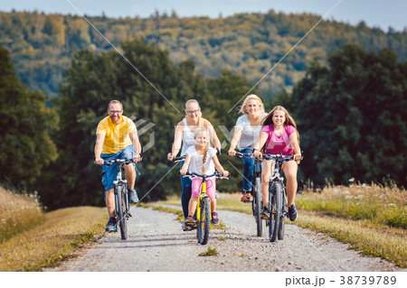 Family riding their bicycles on afternoon in the 38739789