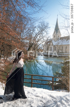 Woman walking through snow on a lakeshore 38739867