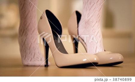 Feet of little girl putting mothers high heel Feet of little girl putting mothers high heel 38740899