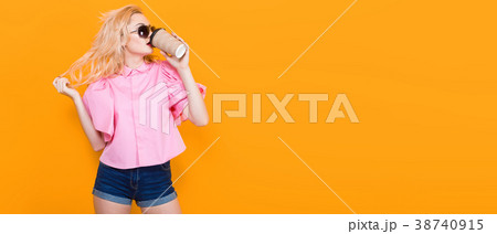 Woman in pink blouse with sunglasses drink coffee Woman in pink blouse with sunglasses drink coffee 38740915